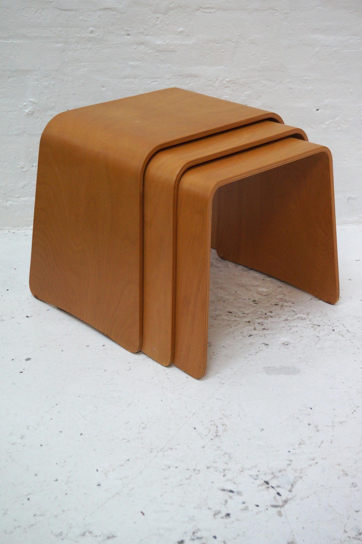 NEST OF THREE BEECH PLYWOOD TABLES of arched form, 46cm high