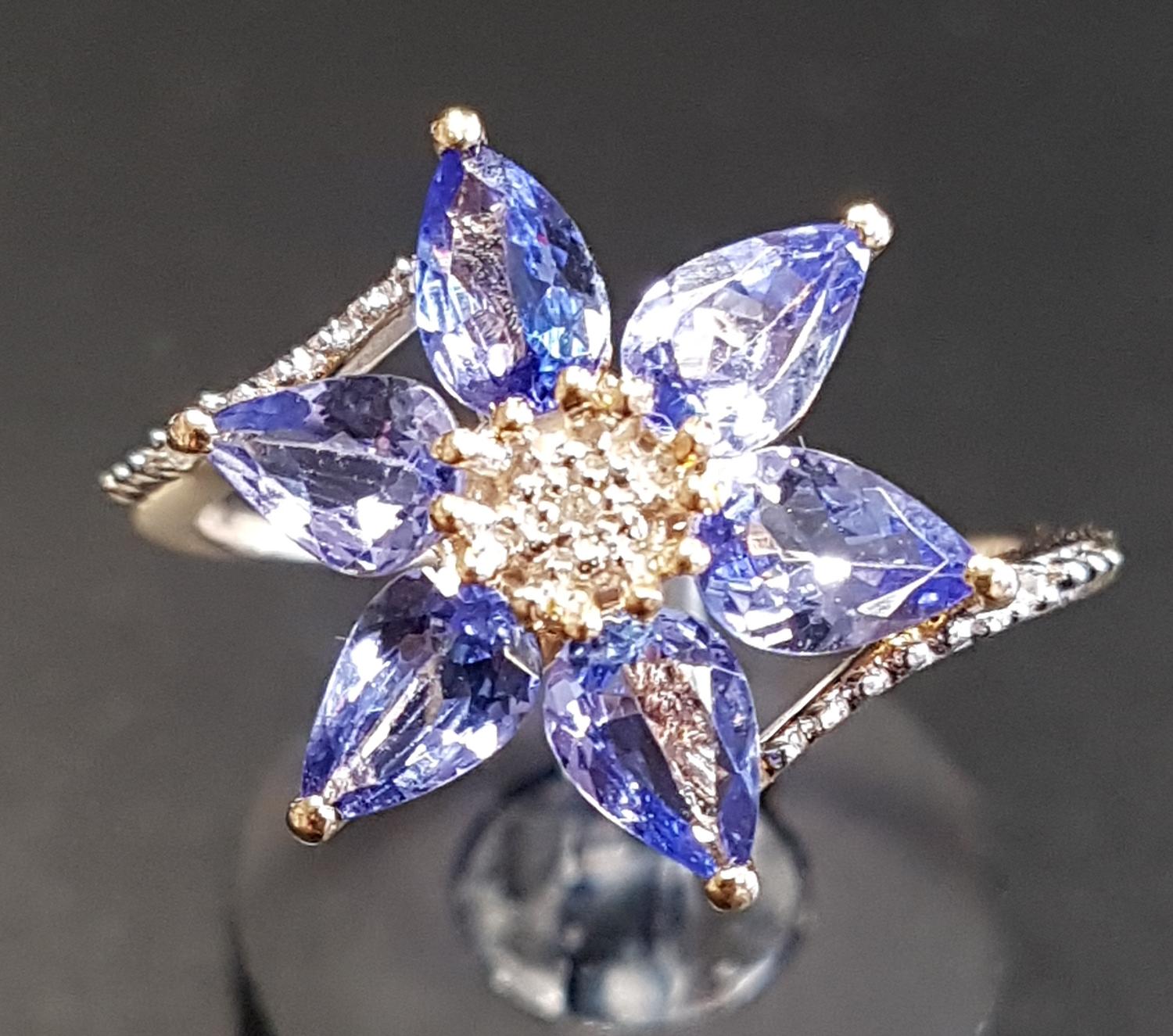 ATTRACTIVE TANZANITE AND DIAMOND CLUSTER DRESS RING the central diamond surrounded by six pear cut