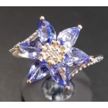 ATTRACTIVE TANZANITE AND DIAMOND CLUSTER DRESS RING the central diamond surrounded by six pear cut