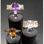 THREE DIAMOND AND GEM SET RINGS comprising an amethyst and diamond cluster ring on silver shank,