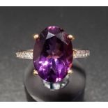 AMETHYST AND DIAMOND DRESS RING the large central oval cut amethyst approximately 5cts, flanked by