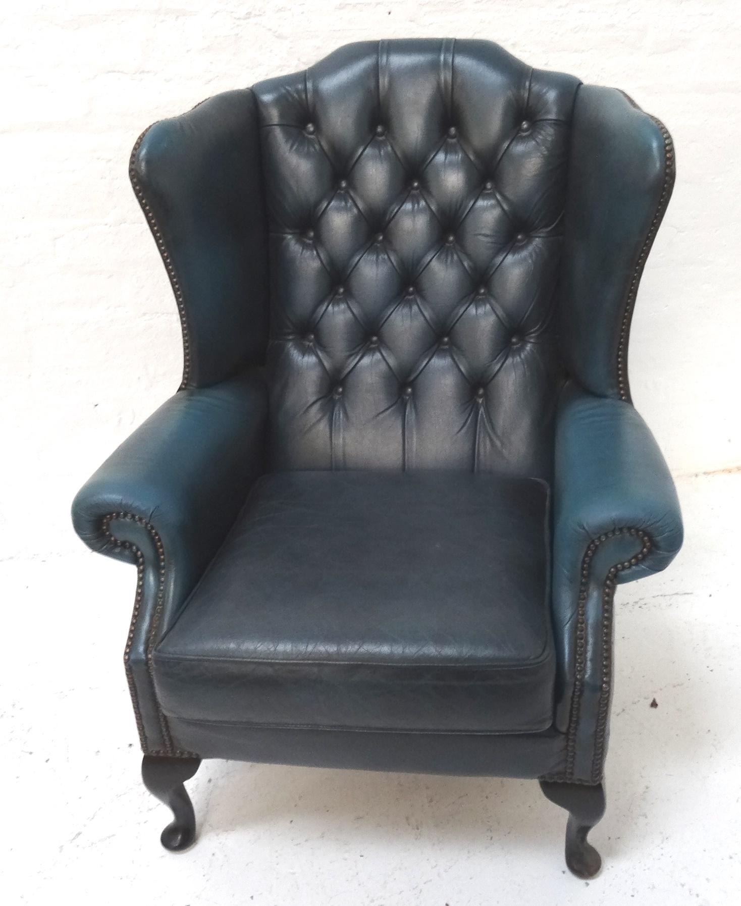 CHESTERFIELD WING BACK ARMCHAIR in blue leather with decorative stud detail, standing on cabriole