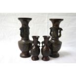 PAIR OF BRONZED EAST ASIAN VASES of bulbous form with decorative panels and twin handled, 19cm high;