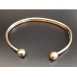 NINE CARAT GOLD BANGLE with ball finials, approximately 5.7 grams
