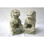 PAIR OF CHINESE DOGS OF FO each seated on a plinth with one paw raised and resting on a ball, in