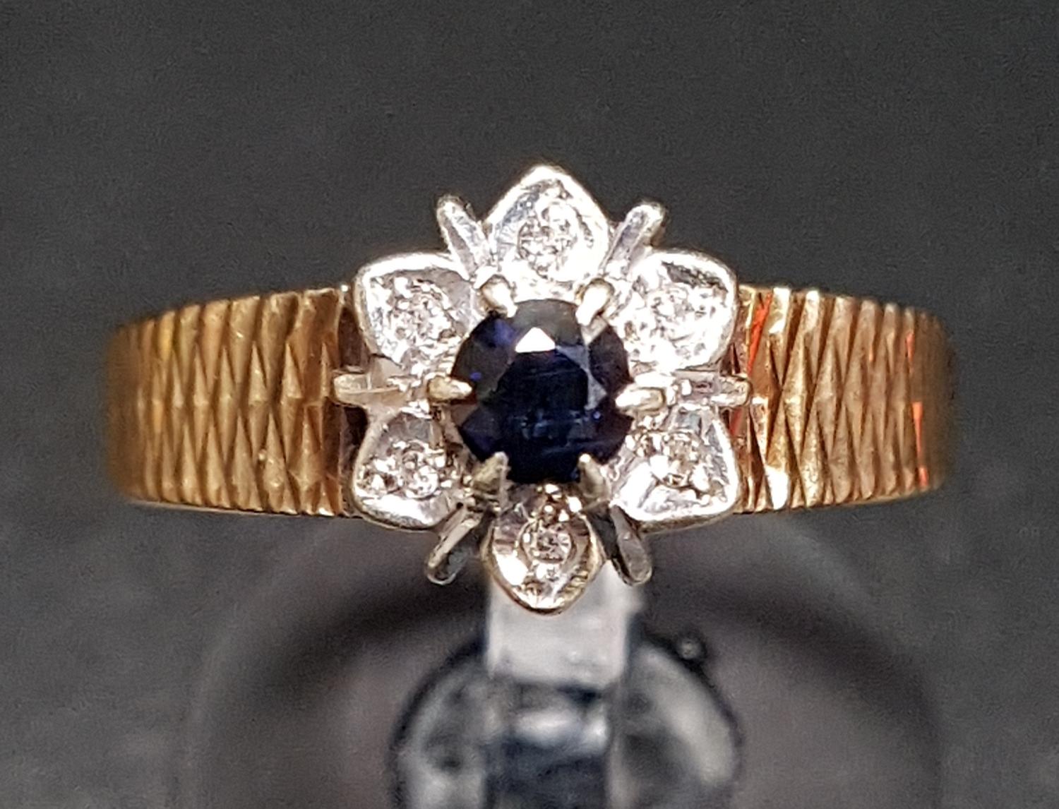 SAPPHIRE AND DIAMOND FLOWER HEAD DESIGN CLUSTER RING the round cut sapphire in surround of six