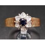 SAPPHIRE AND DIAMOND FLOWER HEAD DESIGN CLUSTER RING the round cut sapphire in surround of six