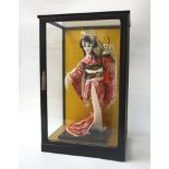 JAPANESE FIGURE OF A GEISHA GIRL IN GLASS CASE the geisha girl in traditional costume, the case