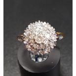 DIAMOND CLUSTER DRESS RING on eighteen carat gold shank with stepped setting, ring size M