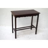 MAHOGANY OCCASIONAL TABLE with an oblong moulded top standing on plain supports with carved