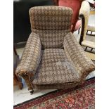 LATE VICTORIAN ARMCHAIR with a padded back and seat with scroll arms, covered in a patterned