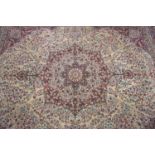 LARGE WILTON RUG with profuse floral decoration centred with a rose, on a burgundy ground, all