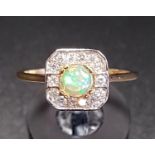 OPAL AND DIAMOND CLUSTER RING the central round cabochon opal in fourteen diamond surround, on