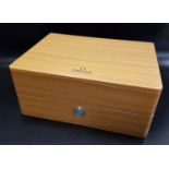 OMEGA WATCH BOX of faux wood design with push button opening mechanism, the fitted cream leather