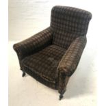 LATE VICTORIAN ARMCHAIR with a padded back and seat with scroll arms, covered in a patterned