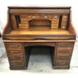 OAK TAMBOUR FRONT ROLL TOP DESK with a moulded top above a tambour front, opening to reveal a fitted