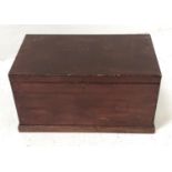 STAINED PINE BLANKET BOX with a lift up lid and side carrying handles, standing on a plinth base,