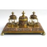 COPPER AND BRASS DESK TOP INKWELL with opposing pen rests, two square glass inkwells flanking a