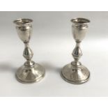 PAIR OF EDWARD VII SILVER CANDLESTICKS with knopped stems and raised on circular bases, London 1908,