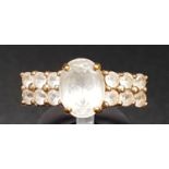 QUARTZ DRESS RING the central oval cut gemstone flanked by two rows of smaller quartz gemstones,