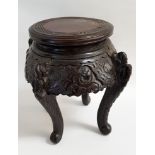 CHINESE CARVED HARDWOOD STAND with a circular top above a carved and pierced frieze, standing on
