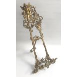 DECORATIVE BRASS EASEL with pierced scroll and floral decoration overall, the top section with a