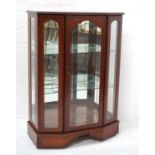 TEAK BOW FRONT DISPLAY CABINET with a moulded top above a central shaped glass door flanked by glass