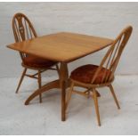 ERCOL LIGHT OAK DINNING TABLE with a pull apart top revealing a fold out leaf, with a turned