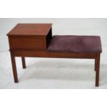 TEAK TELEPHONE TABLE the raised square top with a shelf below and padded seat, standing on plain