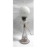 EDWARDIAN CUT GLASS BRASS MOUNTED OIL LAMP with circular cut glass reservoir, raised on a tapered