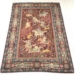 PERSIAN RUG/WALL HANGING with a claret ground decorated with men on horseback hunting wild animals