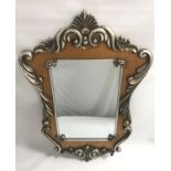 ORNATE WALL MIRROR in a silvered shaped wood frame with a central oblong beveled plate, 107cm high