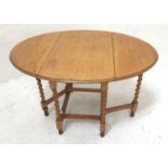 LIGHT OAK GATELEG DINING TABLE with shaped drop flaps, standing on barley twist supports united by