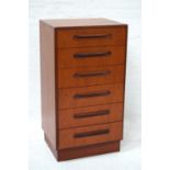 G PLAN TEAK CHEST OF DRAWERS of narrow proportions with six drawers with scroll handles, standing on
