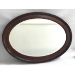 MAHOGANY OVAL WALL MIRROR with a beveled plate, 87.5cm high
