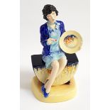 PEGGY DAVIES FIGURINE of Clarice Cliff The Artisan, seated holding a plate and paint brush, 21.5cm