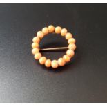CIRCULAR CORAL SET BROOCH in unmarked gold mount, 2.3cm wide