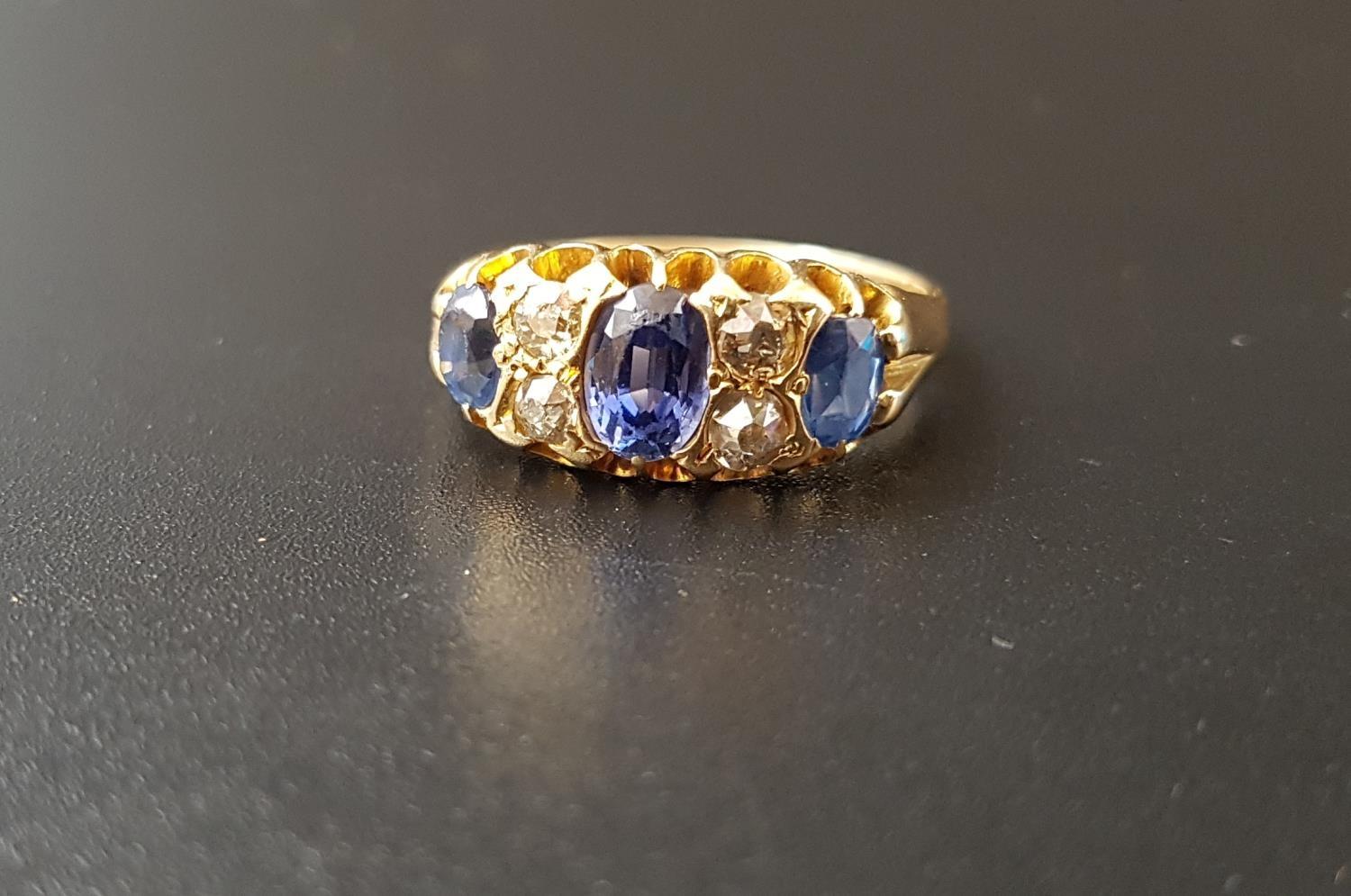 SAPPHIRE AND DIAMOND RING the three graduated oval cut sapphires separated by smaller diamonds, on