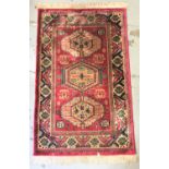 ISFAHAN STYLE RUG with a red ground and three central geometric motifs encased in a decorative