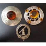 TWO COLOURED GLASS CIRCULAR PLAID BROOCHES one with engraved thistle decoration, the other with