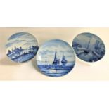 PAIR OF DELFT BLUE AND WHITE PLATES decorated with canal scenes, 25cm diameter, and a larger Delft