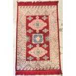 ISFAHAN STYLE RUG with a red ground having three geometric motifs encased in a decorative border,