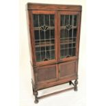 1930s OAK DISPLAY CABINET with a pair of decorative leaded glass doors opening to reveal