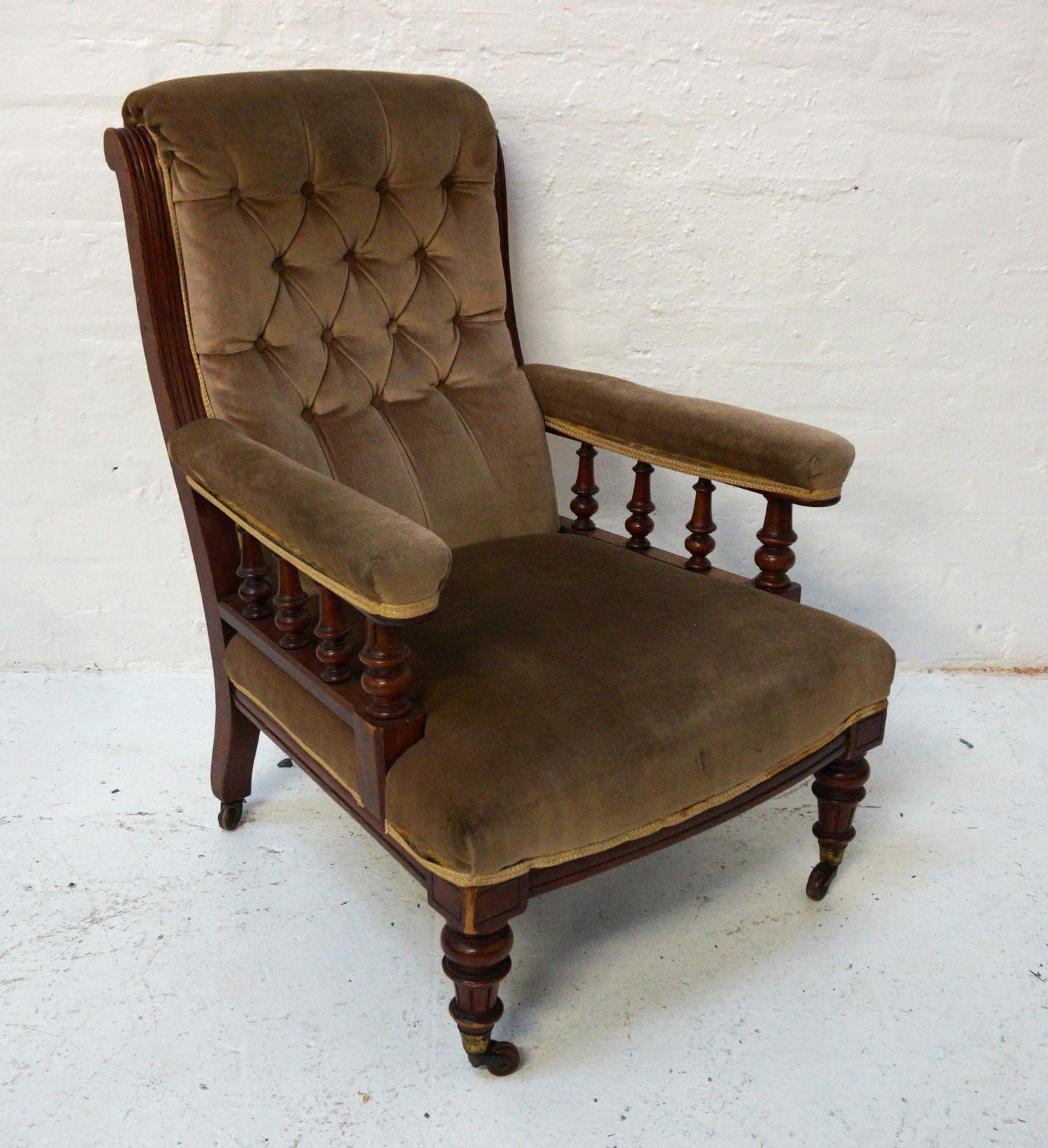 VICTORIAN ARMCHAIR with a mahogany frame and a button back above padded arms with turned supports