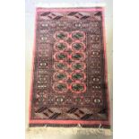 MIDDLE EASTERN PRAYER RUG with a pink ground and multi lozenge central section encased by a