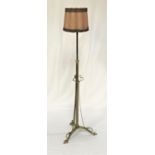 BRASS TELESCOPIC STANDARD LAMP of tubular form raised on a tripod base, with a pleated shade,