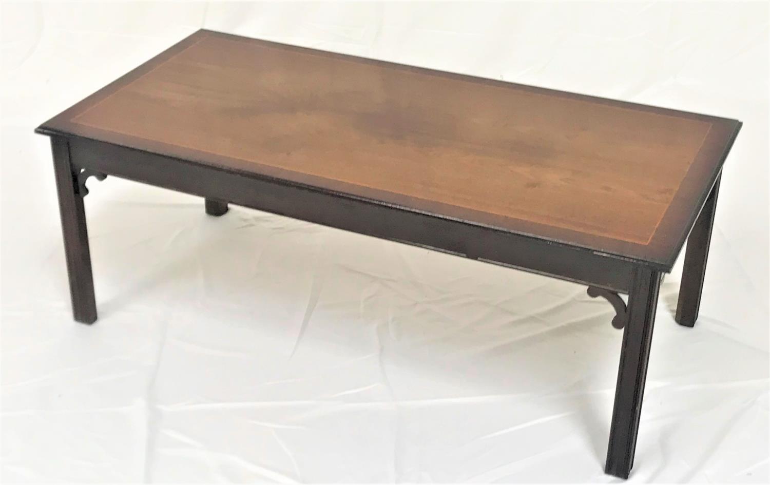MAHOGANY AND CROSSBANDED OBLONG OCCASIONAL TABLE standing on shaped supports, 121cm wide