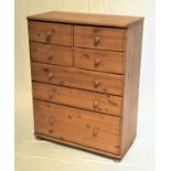 WAXED PINE CHEST with a moulded top above four short and three long graduated drawers with turned