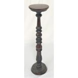 WALNUT TORCHERE with a circular top on a turned carved column with acanthus leaf decoration and a