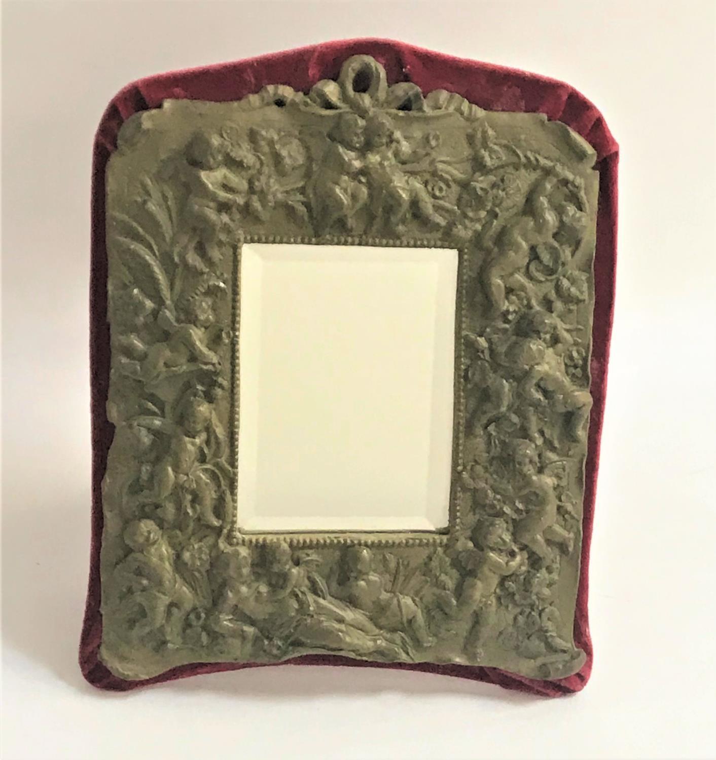 SHAPED DRESSING TABLE MIRROR with a resin frame decorated with cherubs around a bevelled plate,